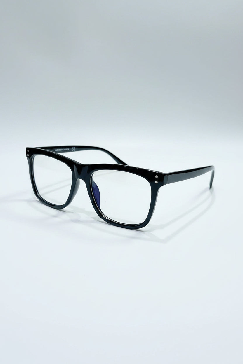 Black eyeglasses on a silver case with a light gray background